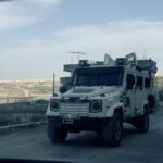 Israeldarren posizioetatik gertu Libanon dauden Nazio Batuetako soldaduen auto armatua Kfar Khila eta Al Nabatiyeh herrietatik gertu dagoen dendaxka baten parean pasatzen. Atzean Israeldarren horma ikusi daiteke. Andoni Lubaki/Ronak Press CC-BY-ND-NC 2026