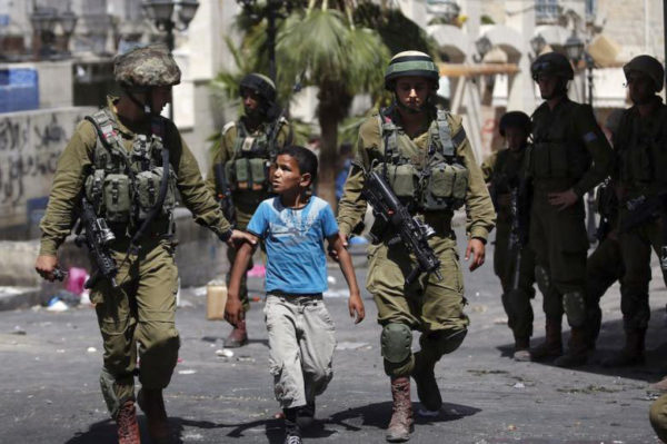 Israelgo Armadako kideak haur bat atxilotzen (Arg: Al Akhbar)